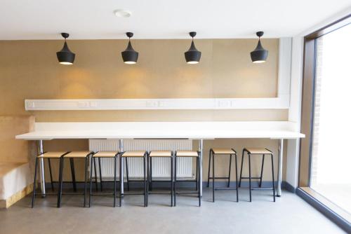 a bar in a room with stools and lights at For Students Only Cosy Ensuites at New Cross in London in London