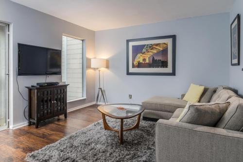 a living room with a couch and a tv at Captain's Quarters Riverfront #3 in Nashville