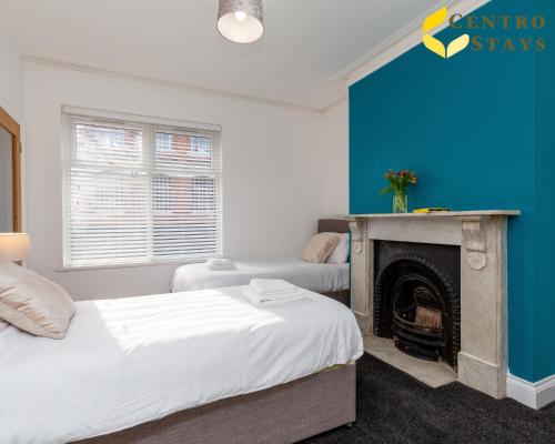 een slaapkamer met 2 bedden en een open haard bij Special Rates Week Month stays Work Relocation FREE PARKING in Northampton