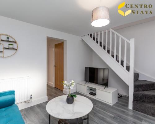 a living room with a table and a staircase at Entire House 3BR 7 Beds Sleeps 8 Ideal for Contractors Families Groups Near Town Centre Hospital Pubs Free Parking WiFi By Centro Stays in Northampton