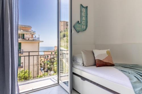 a bedroom with a balcony with a view of the ocean at La Casa di Madi in Riomaggiore
