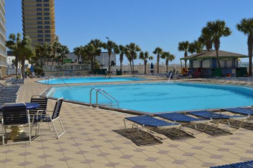 a large swimming pool with lounge chairs and avisorvisor at The Summit Condominiums in Panama City Beach