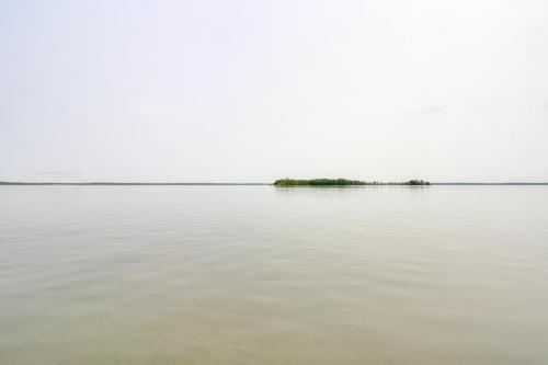 an island in the middle of a body of water at Pelican Lake Retreat with Fire Pit, Dock and Grill! in Breezy Point