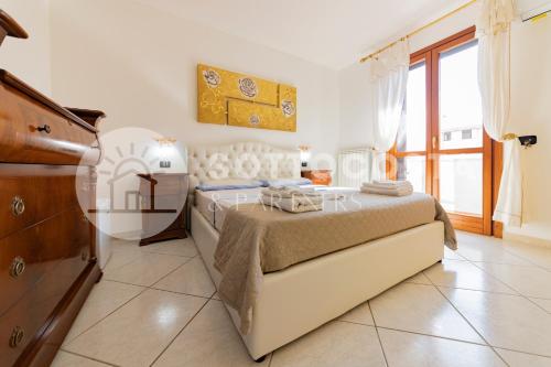 ein Schlafzimmer mit einem Bett und einer Kommode darin in der Unterkunft Villino Montale in Porto Cesareo