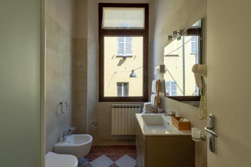 a bathroom with a sink and a toilet and a window at Ca' Tazzoli in Mantova