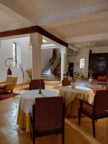 Ksar Oled Cherki的住宿－Auberge Ksar Jallal，客厅设有两张桌子和楼梯