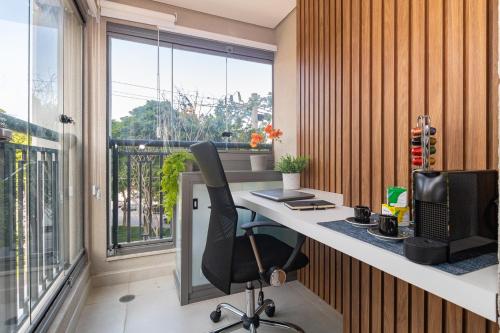 an office with a desk with a computer and a window at Estúdios Aconchegantes na Vila Mariana in Sao Paulo