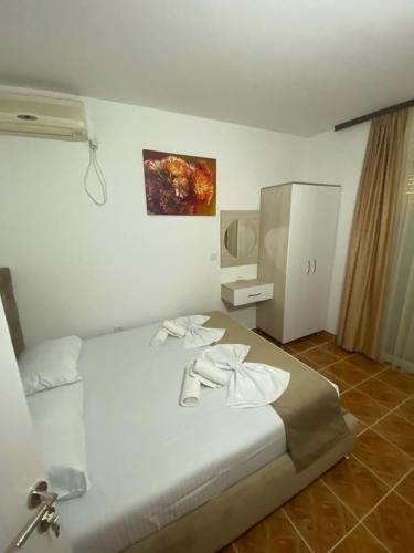 a bedroom with a white bed with towels on it at Apartments Hidri in Ulcinj