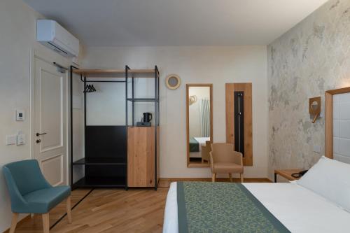 a bedroom with a bed and a chair and a mirror at Cà Uberti Home Boutique, MantegnaHotels in Mantova