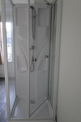 une douche avec une porte vitrée dans une pièce dans l'établissement STUDIO ST MICHEL, à Paris