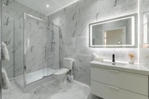 a bathroom with a shower and a toilet and a sink at Luxury Apartment near Central London in London