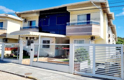 a house with a white gate in front of it at Apartamento Anna Carolina in Florianópolis