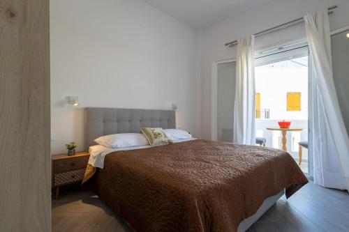 a bedroom with a bed and a large window at Alex Luxury Downtown House in Naxos Chora