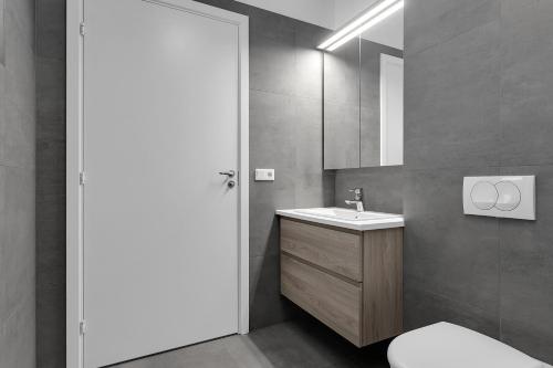 uma casa de banho com um lavatório, um WC e um espelho. em Saga Apartments Reykjavík em Reykjavík