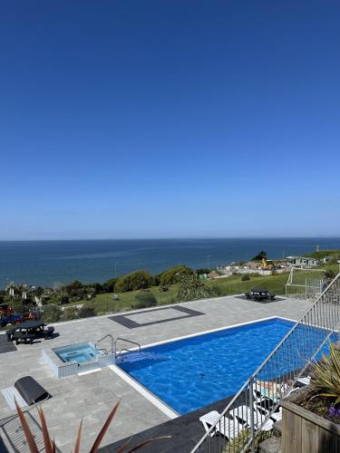 a swimming pool with the ocean in the background at Barmouth Pet-Friendly 2-Bed Caravan with Sea View in Barmouth