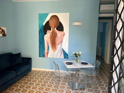 una sala de estar con una mesa de cristal y una pintura en Antica dimora del mare - Luxury suite, en Diamante