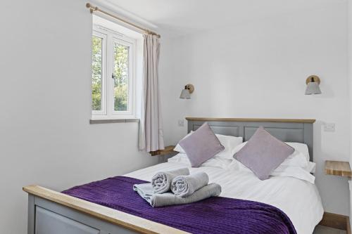 a bedroom with a bed with towels and a window at Luxurious Barn Conversion in Oakamoor