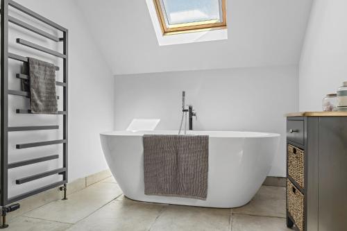 a bathroom with a white tub and a sink at Luxurious Barn Conversion in Oakamoor