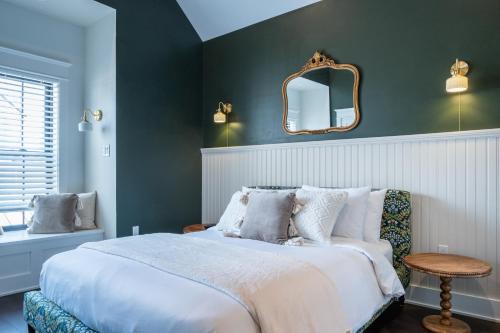 a bedroom with a large bed and a mirror at The Hen Houses in Wildwood