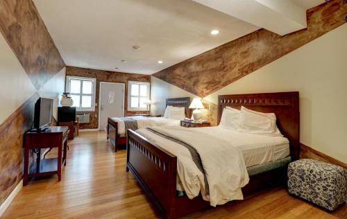 een grote slaapkamer met 2 bedden en een bureau bij Hamilton Village Inn in North Kingstown