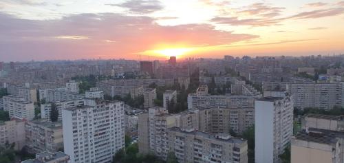 una puesta de sol sobre una ciudad con edificios altos en VApartments en Kiev