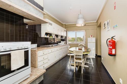 a kitchen with white cabinets and a table at DOME Alvares Cabral in Lisbon