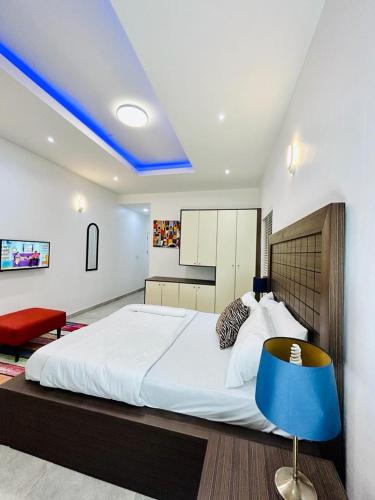 a bedroom with a large white bed and a blue chair at Luxurious1 bedroom apart in VI in Lagos