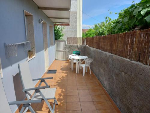 a small balcony with a table and chairs on it at Casa Maside Orense in Maside
