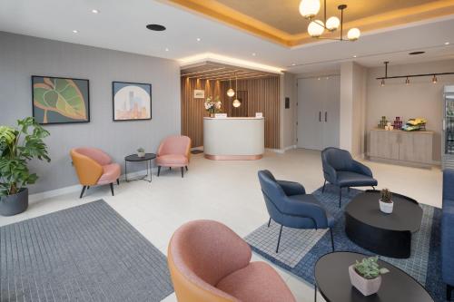 a waiting area in a hospital with chairs and tables at Residence Inn by Marriott Manchester Piccadilly in Manchester