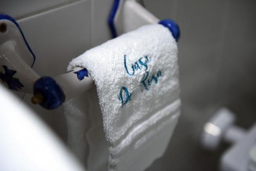 a towel with the words kiss me is hanging on a wall at Casa De Rosa in Atrani