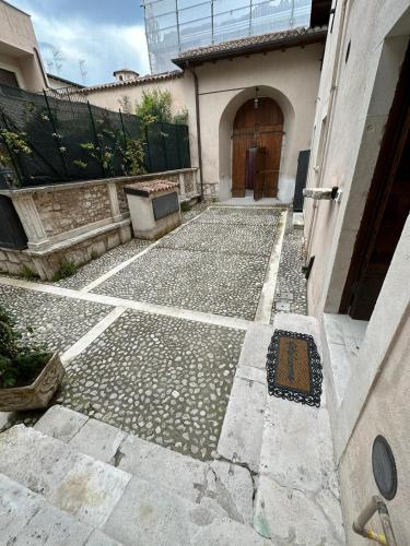 a stone walkway leading to a building with a door at Dimora del Padre Provile 1244 - Centro storico in LʼAquila