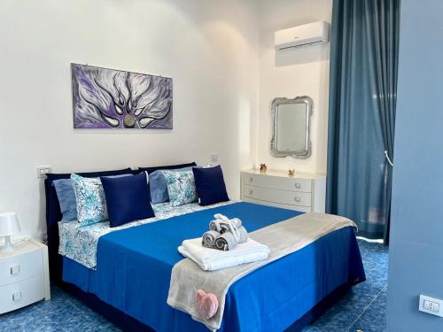 ein Schlafzimmer mit einem blauen Bett und Handtüchern darauf in der Unterkunft Il Sogno in Erchie
