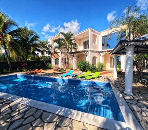 a swimming pool in front of a house at Marisa Residences in La Gaulette