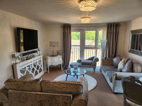 a living room with two couches and a tv at Rothwell in Swansea