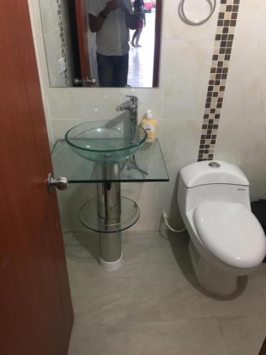 a bathroom with a toilet and a glass sink at QUINTA CAMPESTRE LA FLORIDA in Mariquita