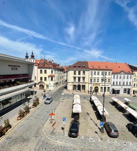 a city street with cars parked in front of buildings at Palác Daun - Studio Apartments in Znojmo