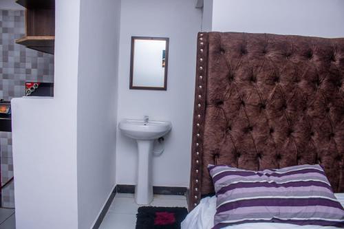 a bedroom with a bed with a sink and a mirror at Rainbow apartment in Mombasa