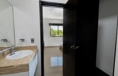 a bathroom with a sink and a mirror at Hotel Ambra in Playa del Carmen