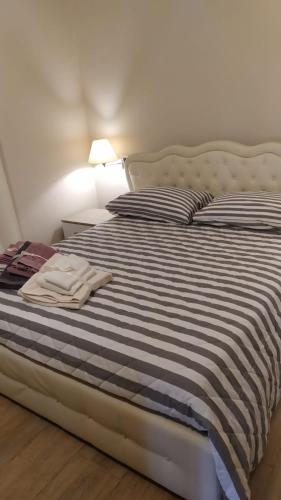 a bed with a blue and white striped comforter at Casa Clorinda in Arezzo