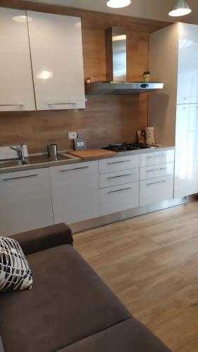 a kitchen with white cabinets and a couch in a room at Casa Clorinda in Arezzo