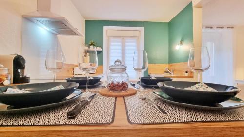 une table avec des assiettes et des verres à vin dessus dans l'établissement La Plume de Jais - Famille ou travail- Fibre - Confortable, à Soultz-Haut-Rhin