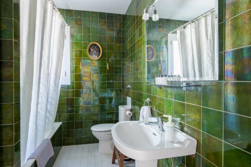 Baño de azulejos verdes con lavabo y aseo en Big Villa Can Pedro in Palma de Mallorca, en Palma de Mallorca