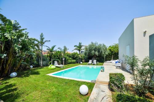 een afbeelding van een achtertuin met een zwembad bij Villa Ponente - Design House with Private Pool in Marina di Ragusa