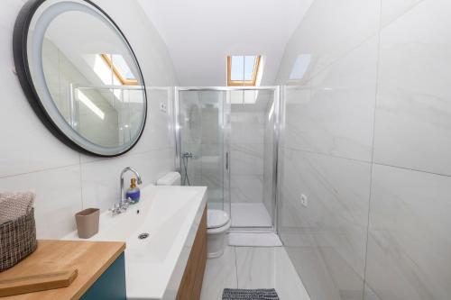 uma casa de banho com um chuveiro, um lavatório e um espelho. em Sunset Apartment em Zadar
