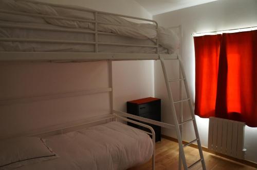 1 Schlafzimmer mit 2 Etagenbetten und einem roten Vorhang in der Unterkunft Maison Le Corbusier in Doncourt-lès-Conflans