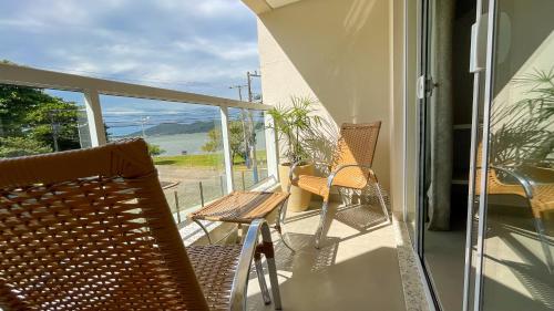 a balcony with chairs and a view of the ocean at Costa Solar Lagoa in Florianópolis