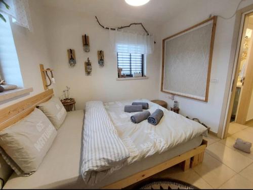 Un dormitorio con una cama con almohadas azules. en צמח בר, en Midreshet Ben Gurion