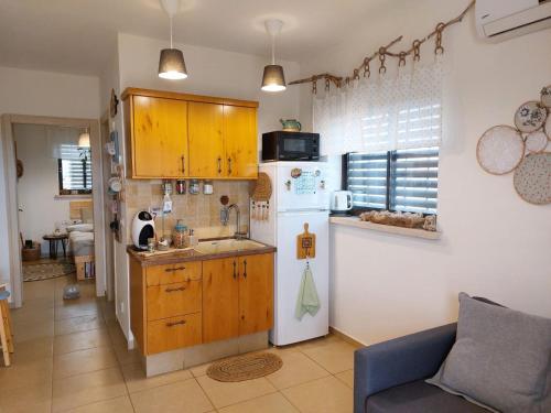 eine Küche mit gelben Schränken und einem weißen Kühlschrank in der Unterkunft צמח בר in Midreshet Ben Gurion