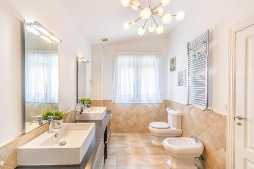 a bathroom with two sinks and a toilet and a mirror at Casa Valdizarbe, espaciosa casa rural próxima a Pamplona in Biurrun