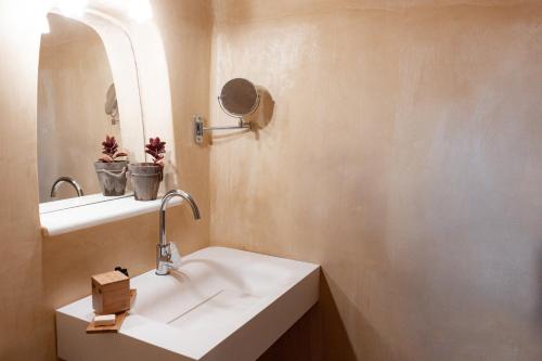a bathroom with a sink and a mirror at XARAKI Traditional Houses in Chora Folegandros